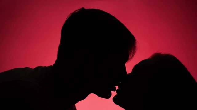 color background. 4k, slow motion. shadow of a man. couple, man and woman kissing
