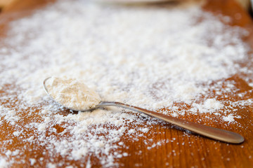 Top side view on white flour on rustic wooden table background, closeup of healthy cooking copyspace surface at home or restaurant.