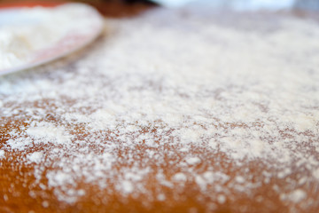 Top side view on white flour on rustic wooden table background, closeup of healthy cooking copyspace surface at home or restaurant.
