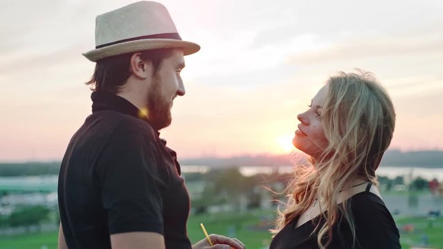 Young European couple dancing together and enjoying sunset at summer rooftop party