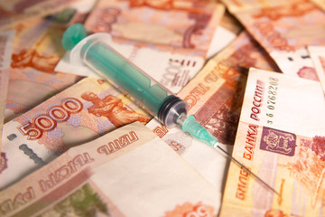 Russian banknotes and medical syringe
