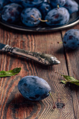 Ripe plums with leaves and knife