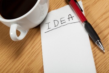 Cup of Coffee with Word Idea on Napkin