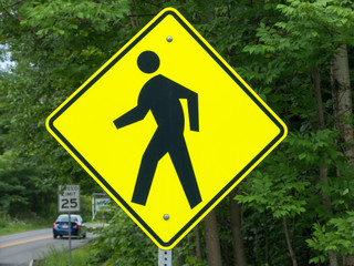Walking or Pedestrian Sign near a road with a car on background