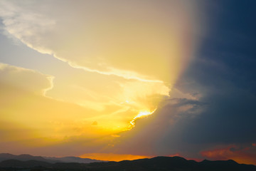 Beautiful sunset with the sun of orange tones behind the mountains and deep blue sky