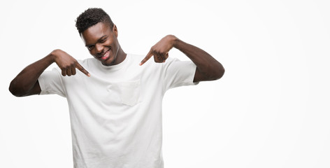 Young african american man wearing white t-shirt looking confident with smile on face, pointing oneself with fingers proud and happy.