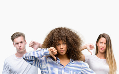 Group of young people over white background with angry face, negative sign showing dislike with...