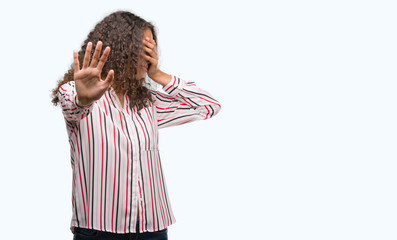 Beautiful young hispanic woman covering eyes with hands and doing stop gesture with sad and fear expression. Embarrassed and negative concept.