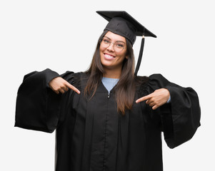 Young hispanic woman wearing graduated cap and uniform looking confident with smile on face,...