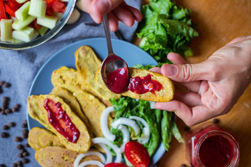 Crispy corn breads slices. Spicy and tasty on plate with green salad leaves, onion rings and tomatoes. Vegan lunch or vegetarian dinner. Healthy food concept.