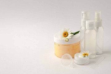Cosmetic bottle containers with camomole flowers, Blank label package for branding mock-up, Natural organic beauty product concept