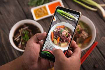 hand taking picture of delicious traditional food