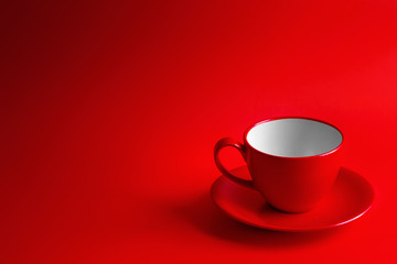 Red coffee cup and saucer on a red background