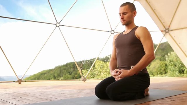 A yoga guy sits in the seisa position