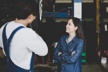 Happy asian girl in the service of the young mechanic. Repair service.