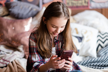 internet is endless source of information. online website entertainment resources. mobile apps. little girl browsing smartphone at home. child using phone
