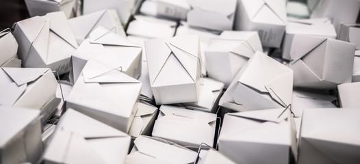 Chinese food takeout boxes stacked in big pile.