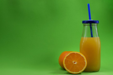 A glass with fresh aleklin juice and an orange lies beside it.