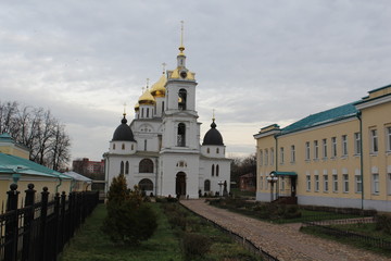 Church courtyard with a yellow rectangular building and a white simple church