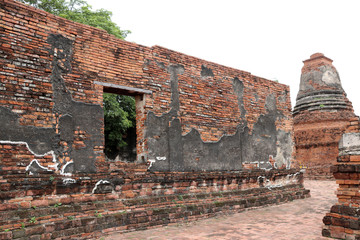 The brick wall with window of church and small stupa in the ruins of ancient remains at Wat Worachet temple, it built in 1593 AD in the Ayutthaya period.