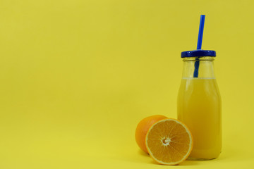 A glass with fresh aleklin juice and an orange lies beside it.