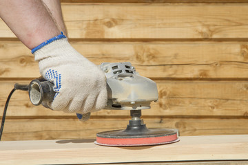  man will work wood with a grinding machine