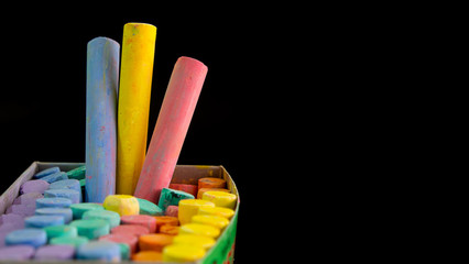 Fototapeta premium Multi color chalks on black background for copy space