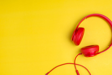 Red headphones listens to music on smartphone over yellow background,Music background concept with copy space.