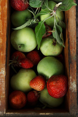 Fresh green apples and strawberry in a wooden box. Rustic. Flat lay