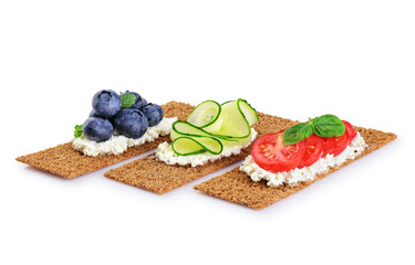 Crispbread with cheese, vegetables and berries isolated on white background.