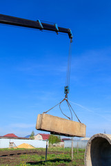 The crane loads old concrete blocks at the construction site