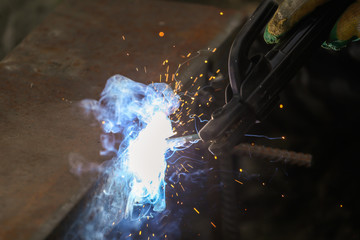 Obraz na płótnie Canvas Worker welds metal at the construction site