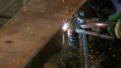 Worker welds metal at the construction site