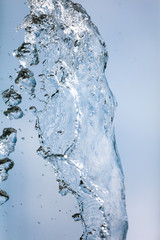 Splashing water with drops on the sky background