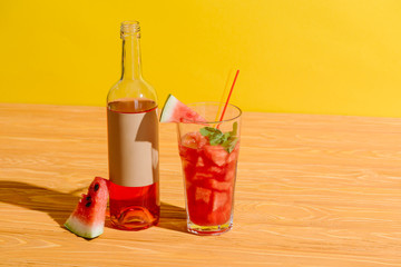 close up view of fresh watermelon and watermelon drink on wooden surface on yellow background