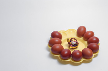 Eggs of Easter, brown on a tray. With a toy from the clay in the center of the composition.