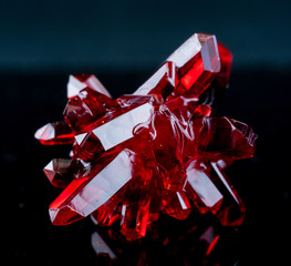 red crystal of natural origin. close up of crystals in ruby color on black background