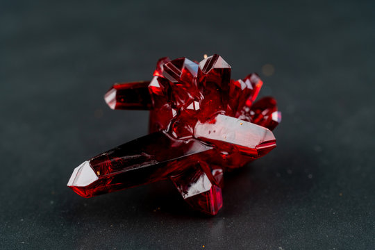 red crystal of natural origin. close up of crystals in ruby color on black background
