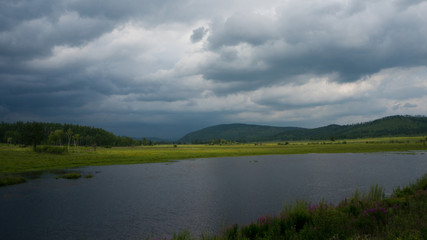 thunderstorm clouds are coming to dark lake