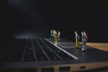miniature business people on laptop watching to laptop monitor.