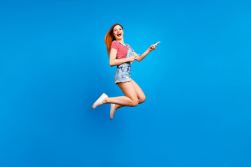 Obraz premium Full-size excited cheerful careless girl demonstrating empty place isolated on vivid blue background with copy space for text