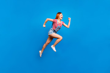 Obraz premium Full-size portrait of running marathon girl who looks in front of her isolated on bright blue background