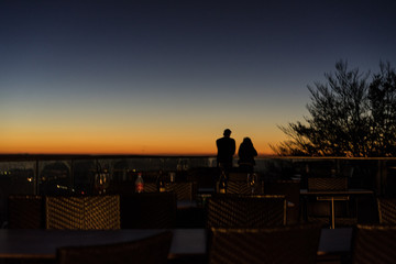 Naklejka na ściany i meble romantic couple at sunset seen from far away