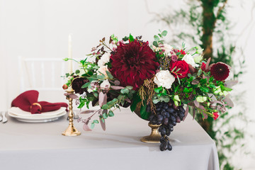 Wedding decorations with fresh red and vinous color flowers close up. Flowers arrangement on party
