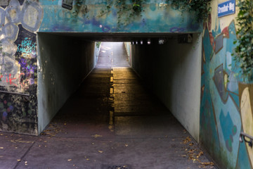 underpass in urban city with light at the end