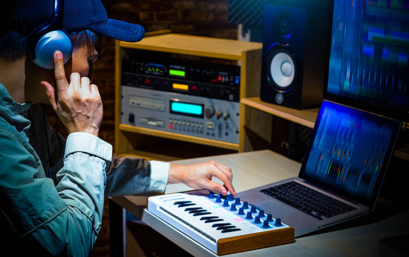 asian male music producer composing a song in digital sound studio