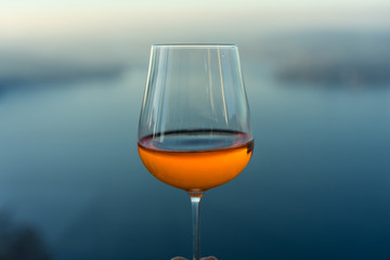 wine glass with drink in front of blue lake iconic background