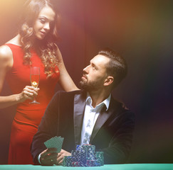 beautiful couple looking at playing cards at poker