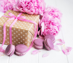 Fototapeta na wymiar pink macaroons with peonies and gift box