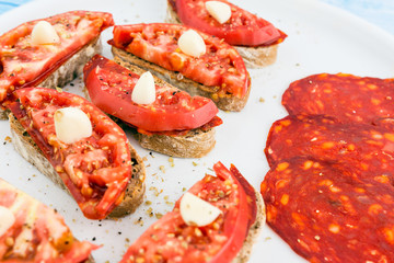 Freshly Cooked Little Sandwiches With Brown Bread Smoked Salami Fresh Bio Organic Tomatoes And Garlic In White Big Dish Closeup